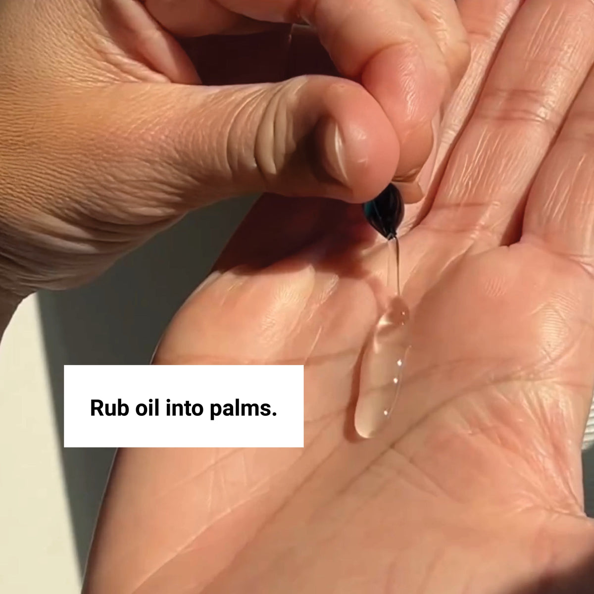 vegan hair oil drop being applied to palm for nourishing and shining hair treatment