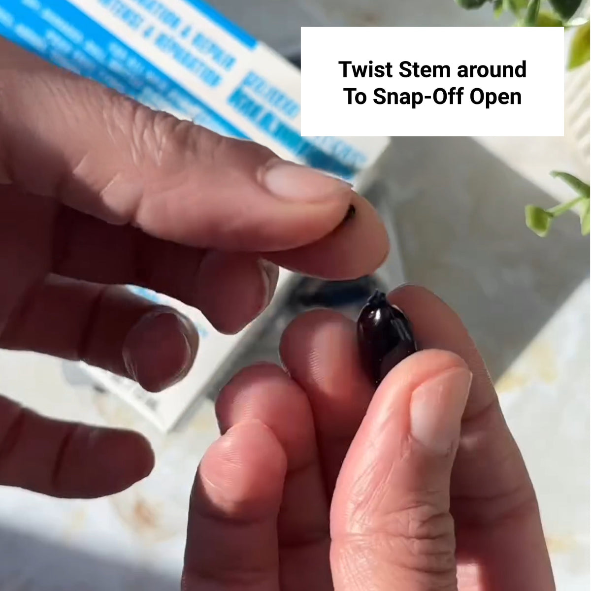 Close-up of hands twisting stem to open a HYDRAMEND Vegan Hair Oil capsule for intense hydration and repair