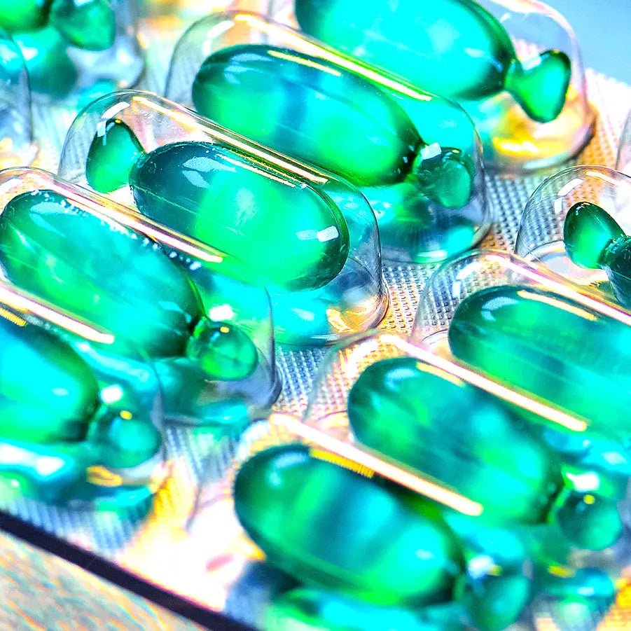 close-up of green BODYDENSE Vegan Hair Oil capsules in blister packaging